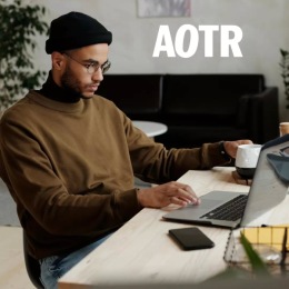 a person working on a laptop holding a coffee