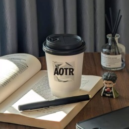 a coffee book pen and action figure on a desk